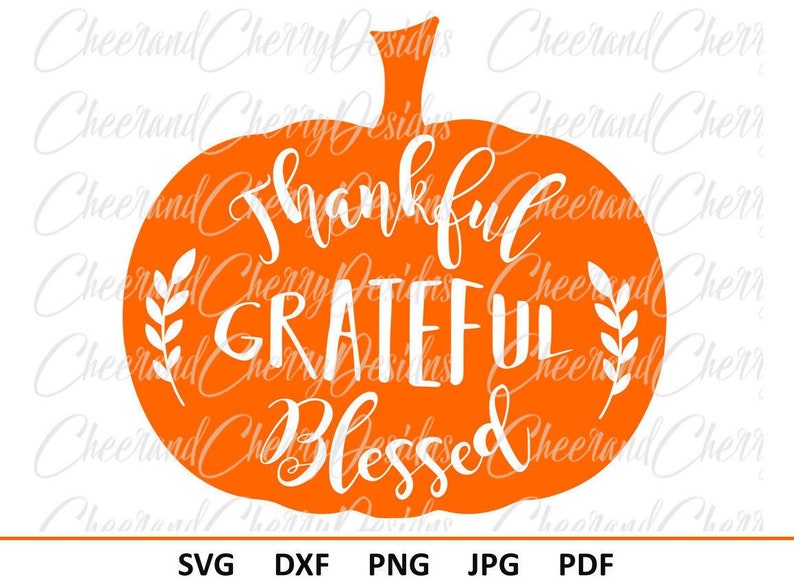 May include: Orange pumpkin silhouette with the text "Thankful Grateful Blessed" in white lettering. The pumpkin has a stem and leaves on either side of the text.
