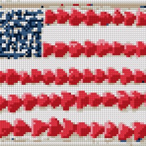 May include: A cross-stitch depiction of the American flag. The flag features a blue square with white stars in the upper left corner, and red and white stripes made of arrows. The design is framed with a white border.
