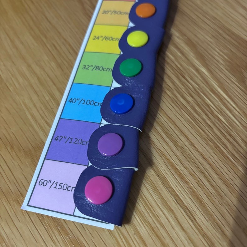 May include: A purple leather strap with color coded dots for different lengths. The strap is labeled with measurements in inches and centimeters: 20/50cm, 24/60cm, 32/80cm, 40/100cm, 47/120cm, 60/150cm.