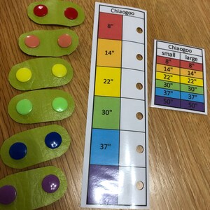 May include: A set of colorful circular buttons in various sizes, arranged in rows on green oval-shaped pieces of fabric. A chart with the text "Chiaogoo" and measurements in inches is shown on the right side of the image.