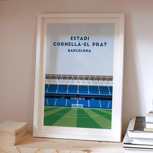 Puede incluir: Impresión enmarcada del estadio Estadi Cornellà-El Prat en Barcelona. La obra presenta una ilustración detallada de los asientos azules del estadio, el campo verde y el texto "Estadi Cornellà-El Prat Barcelona" en azul.