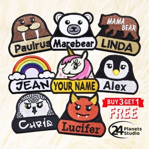 May include: Ten colourful iron-on patches with various animal designs and names. The patches include a rainbow, a unicorn, a penguin, a polar bear, a walrus, a devil, an owl, and a bear. The patches are for sale and include the text "BUY 3 GET 1 FREE" and "24 Planets Studio".