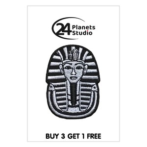 May include: Black and white embroidered iron-on patch of an Egyptian pharaoh's head with a headdress. The patch is surrounded by a black outline. The text "24 Planets Studio" is in the top left corner of the image. The text "BUY 3 GET 1 FREE" is at the bottom of the image.