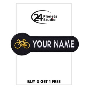 Pode incluir: Patch bordado preto e branco com um ícone de bicicleta amarelo e o texto "YOUR NAME".
