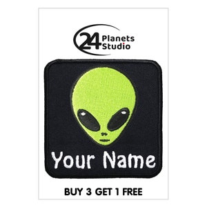 Op de afbeelding: Zwarte en groene geborduurde strijkpatch met een cartoon-aliengezicht en de tekst "Your Name".
