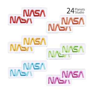 May include: Set of 24 iron-on patches featuring the NASA logo in various colors, including red, orange, yellow, green, blue, and pink. The patches are rectangular and have a white background.
