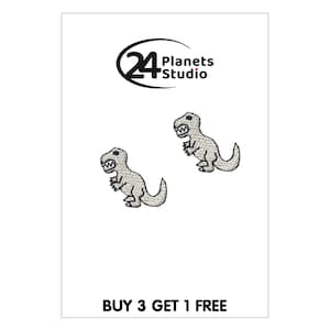 Puede incluir: Dos parches de hierro bordados blancos de un dinosaurio de dibujos animados con el texto "BUY 3 GET 1 FREE" en la parte inferior.
