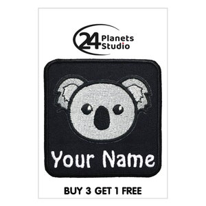May include: Black and white embroidered iron-on patch featuring a cartoon koala with the text "Your Name" below. The patch is square shaped and has a black background.