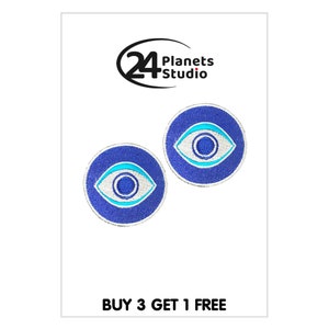 Peut inclure: Deux patchs brodés de mauvais œil bleus et blancs avec le texte "BUY 3 GET 1 FREE" en bas de l'image.