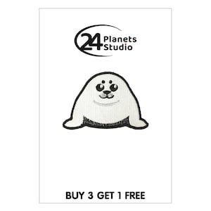 May include: White embroidered iron-on patch of a cartoon seal with black eyes, nose, and mouth. The seal is sitting on its belly with its flippers outstretched. The text "BUY 3 GET 1 FREE" is at the bottom of the image.