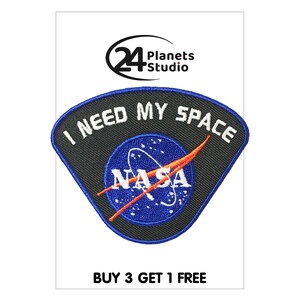 May include: Black and gray embroidered patch with the text "I NEED MY SPACE" and the NASA logo in blue and orange. The patch has a white border and the text "BUY 3 GET 1 FREE" is below the patch.