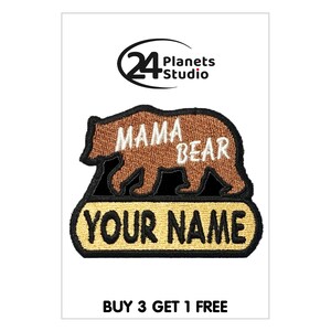 Könnte beinhalten: Braunes gesticktes Bügeleisen-Patch mit einer braunen Bärensilhouette. Der Bär trägt die Worte "Mama Bear" auf sich. Unter dem Bären befindet sich ein gelbes Banner mit den Worten "Your Name" darauf.
