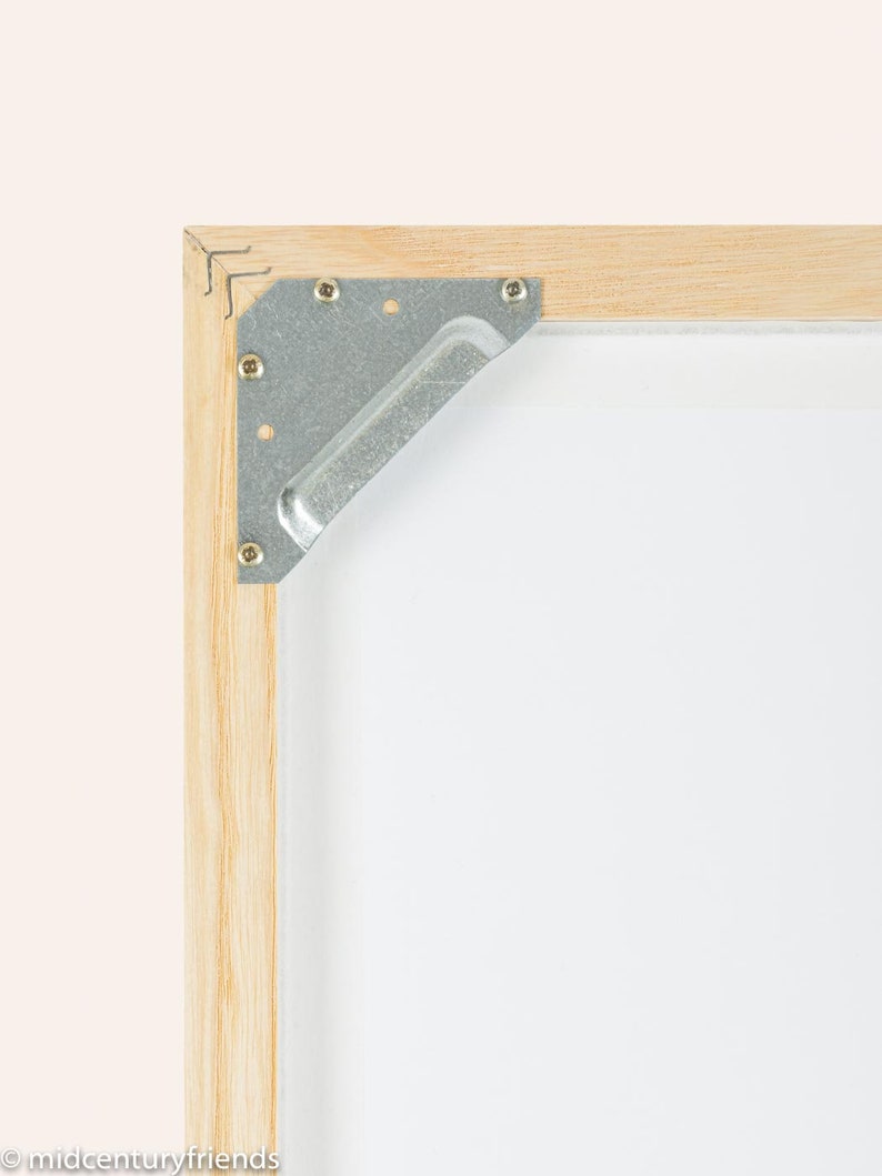 Puede incluir: Primer plano de una esquina de un marco de madera con una escuadra de esquina de metal. La escuadra est&aacute; asegurada con peque&ntilde;os tornillos.