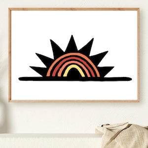 May include: A framed art print featuring a stylized sun and rainbow design. The sun is depicted with black spiky rays, and the rainbow showcases bands of red, orange, and yellow. The artwork is set against a white background, with a wooden frame.