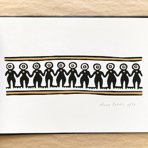 K&ouml;nnte beinhalten: Schwarz-goldener Druck einer Reihe von Figuren, die sich an den H&auml;nden halten. Der Druck ist signiert mit "Nanna Colors 1/50".