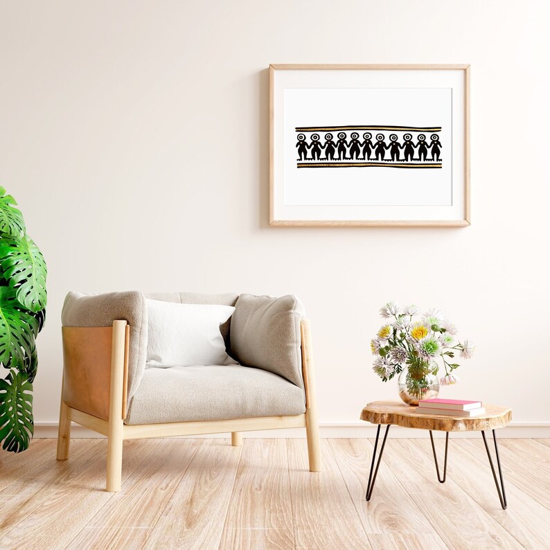 K&ouml;nnte beinhalten: Ein hellgrauer Sessel mit Holzrahmen und einem wei&szlig;en Kissen steht in einem Raum mit Holzboden. Ein gerahmtes Bild mit einem schwarzen und goldenen Design h&auml;ngt an der Wand. Ein kleiner Holztisch mit schwarzen Metallbeinen steht im Vordergrund mit einer Vase mit wei&szlig;en und gelben Blumen und einem Stapel B&uuml;cher.