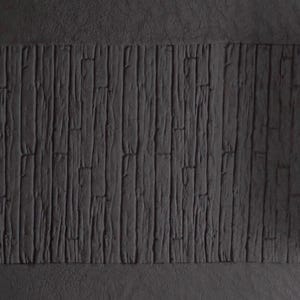 May include: A close-up of a black textured rubber stamp with a wood grain pattern. The stamp is rolled up and ready to be used.