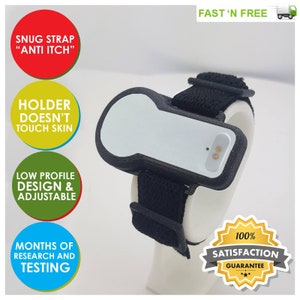 Puede incluir: Una pulsera blanca y negra con un pequeño dispositivo blanco adjunto. El dispositivo tiene un pequeño agujero en la parte superior y dos pequeños puntos dorados en el lateral. La pulsera está hecha de un material negro suave y tiene una correa ajustada. El texto "SNUG STRAP "ANTI ITCH"" es visible en rojo. El texto "HOLDER DOESN'T TOUCH SKIN" es visible en amarillo. El texto "LOW PROFILE DESIGN & ADJUSTABLE" es visible en verde. El texto "MONTHS OF RESEARCH AND TESTING" es visible en azul. El texto "FAST 'N FREE" es visible en verde. Una estrella amarilla con el texto "100% SATISFACTION GUARANTEE" es visible en la esquina inferior derecha.