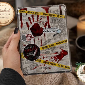 May include: A clear tablet case featuring a true crime theme with a newspaper background, yellow crime scene tape, a red handprint, and text including "I'm basically a detective," "True crime all the time," and "If it's not a thriller I don't want it."