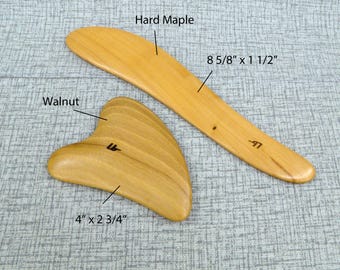 May include: Two Gua Sha massage tools, one made of walnut wood and shaped like a heart, measuring 4 inches by 2 3/4 inches, and the other made of hard maple wood and shaped like a long, thin blade, measuring 8 5/8 inches by 1 1/2 inches.
