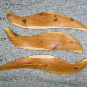 Puede incluir: Tres piezas de madera de enebro, cada una con forma de ola, con diferentes longitudes: 11 5/8 pulgadas, 11 3/8 pulgadas y 12 1/2 pulgadas. La madera es de color marrón claro con un patrón de veta natural.