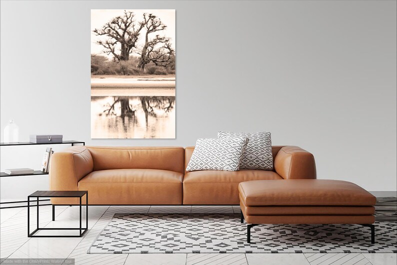 May include: A sepia toned photograph of a large tree with its reflection in a body of water. The tree is bare and has many branches. The water is calm and reflects the tree perfectly.