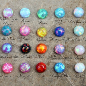 Op de afbeelding: Een verzameling ronde, kleurrijke opaalstenen in verschillende tinten, waaronder roze, blauw, groen en geel. Elke steen is gelabeld met een unieke naam, zoals "Bubble Gum Pink", "Azure" en "Kiwi".