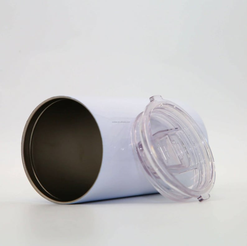 K&ouml;nnte beinhalten: Ein wei&szlig;er Edelstahlbecher mit einem durchsichtigen Plastikdeckel. Der Becher ist leer und der Deckel ist abgenommen.