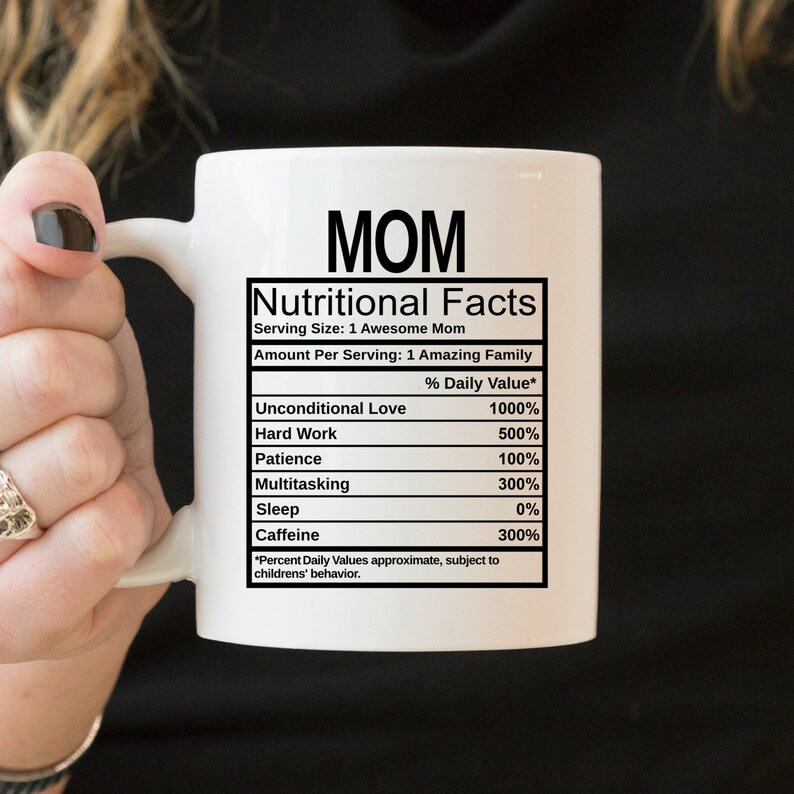 May include: A white ceramic mug featuring black text that reads MOM Nutritional Facts, listing ingredients like Unconditional Love 1000%, Hard Work 500%, Patience 100%, Multitasking 300%, Sleep 0%, and Caffeine 300%, with a disclaimer about children's behavior.