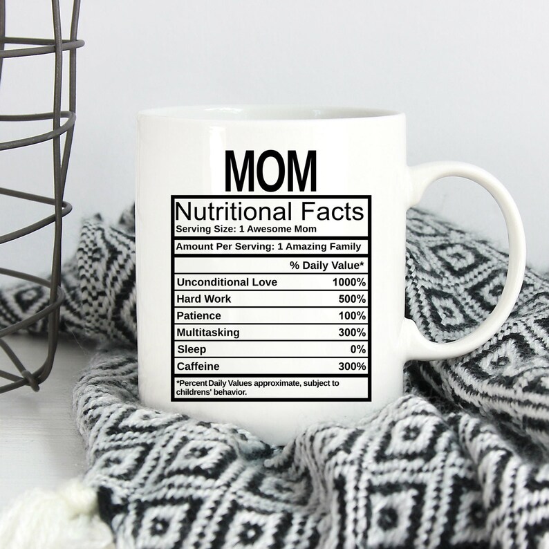 May include: A white ceramic mug featuring black text that reads MOM followed by a Nutritional Facts label. The label lists ingredients including Unconditional Love at 1000%, Hard Work at 500%, Patience at 100%, Multitasking at 300%, Sleep at 0%, and Caffeine at 300%.