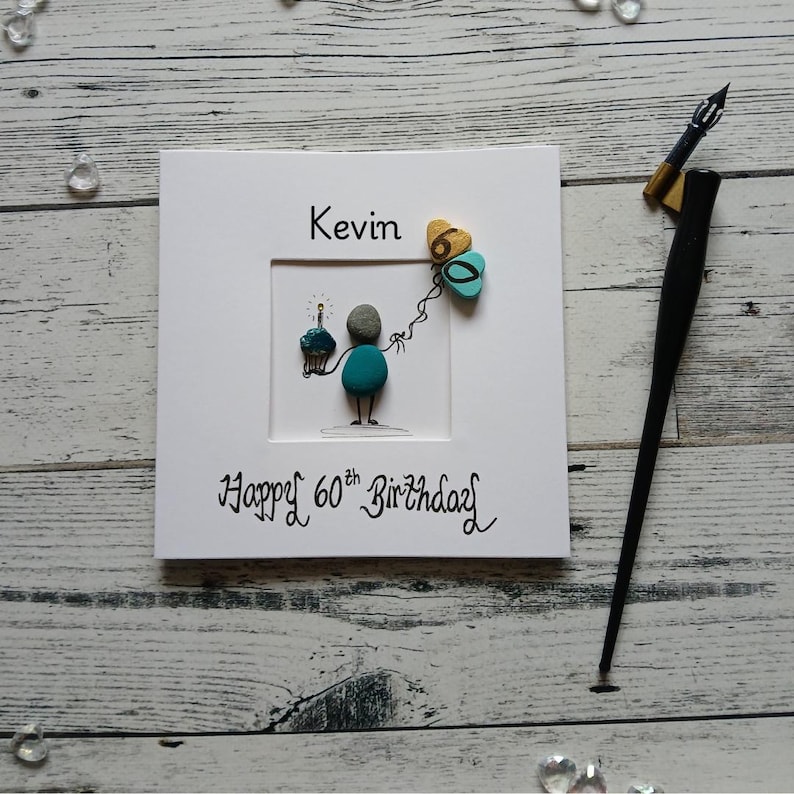 Personalised 60th birthday for him, luxury handmade pebble art card, green painted pebble figure holding a cake, Happy 60th birthday