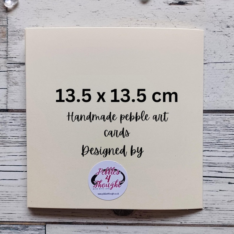 May include: A square off-white card measuring 13.5 x 13.5 cm with black text that reads 13.5 x 13.5 cm, Handmade pebble art cards, Designed by, and a circular logo sticker at the bottom featuring the text Pebbles 4 Thought.