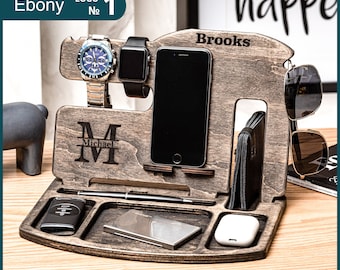 May include: A wooden organizer with multiple compartments for holding a watch, phone, sunglasses, and other items. The organizer is personalized with the name "Brooks" and the initial "M" for Michael. The organizer is made of dark wood and has a natural finish.