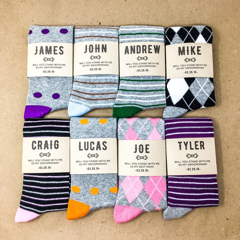 8 pairs of mix and match groomsmen dress socks with custom proposal labels. Groomsmen proposal gift for wedding party. Personalized label includes name, will you stand with me as my groomsman; and wedding date.