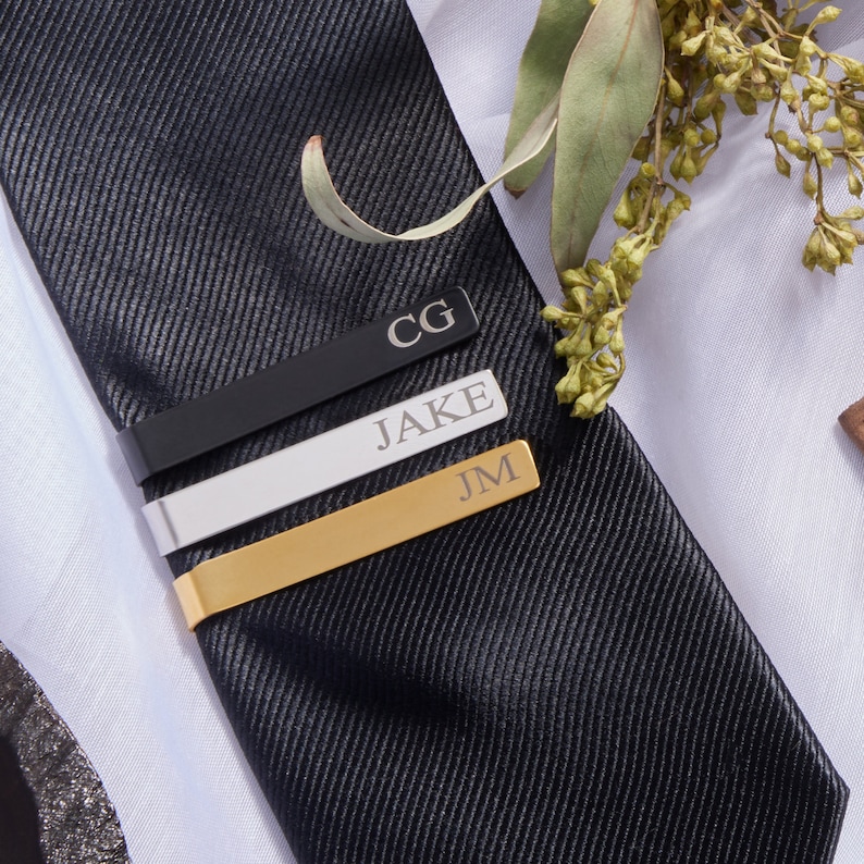 Groomsmen gift box comes with personalized tie clip. Customize tie clip with initials or groomsman's name. Black, Silver and Gold finish available for time to suit up groomsman gift box.
