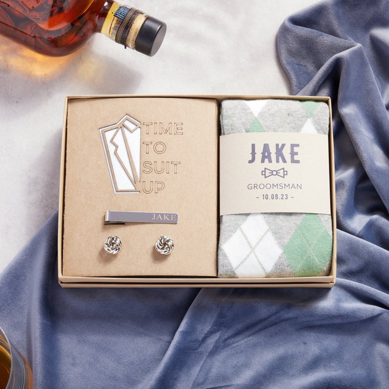 Time to Suit up groomsman gift box. Kraft gift box includes sage green argyle socks with custom groomsman sock proposal label, silver plated custom tie clip and silver plated knot cufflinks. Gift for Groomsman on wedding day.