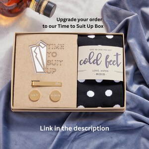 Upgrade your Groom Survival Box to our Time to Suit Up No Cold Feet Gift Box. Time to Suit up Gift box includes one pair of socks, engraved tie clip and personalized cufflinks. Link to this product is in the description.