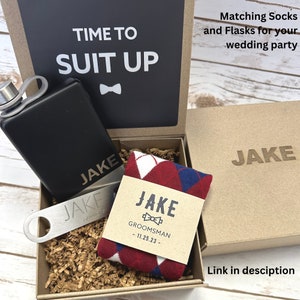 We have matching socks and flask for your entire wedding party. Order our groomsman magnetic gift boxes for your best man, groomsmen, and ushers. The groomsman gift box includes, socks, custom sock label, flask and bottle opener. Link in description.