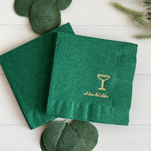 Celebrate a milestone in style with these charming A Tini Bit Older Martini Cocktail Napkins, the perfect addition to any martini-themed birthday party or sophisticated gathering. Designed for lovers of elegant cocktails, these foil-stamped napkins feature a chic illustration of a classic coup martini glass wrapped with a delicate bow around the stem, adding a playful yet refined touch to your celebration. These are perfect for any age birthday, give them as gift for the martini lover.