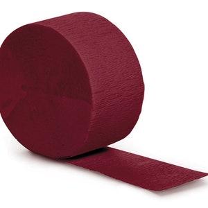 May include: A roll of burgundy crepe paper streamer. The streamer is rolled up and a portion of the streamer is unrolled.