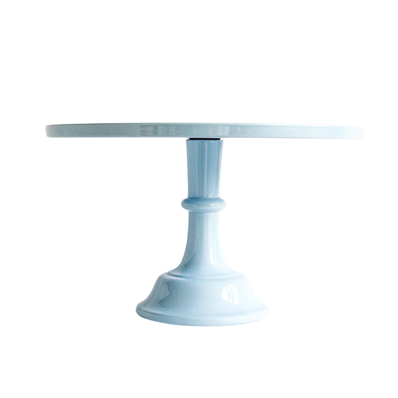 Puede incluir: Un soporte para tartas de color azul claro con una base redonda y un pedestal &uacute;nico. El soporte est&aacute; hecho de cer&aacute;mica y tiene un acabado liso y brillante.