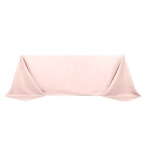 May include: A light pink rectangular tablecloth, draped over a surface. The fabric is smooth and appears to be made of a soft material. The tablecloth is folded at the corners, creating a clean, elegant look. The color is a pale, neutral shade.