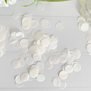 May include: White paper confetti circles scattered on a white surface. The confetti is made of thin, delicate paper and is perfect for adding a touch of elegance to any celebration.