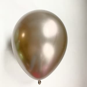 Op de afbeelding: Een enkele, metallic bronzen ballon tegen een witte achtergrond. De ballon heeft een glanzend, reflecterend oppervlak en is opgeblazen. De ballon is aan de onderkant vastgebonden met een zilveren touwtje. Perfect voor feestdecoraties.