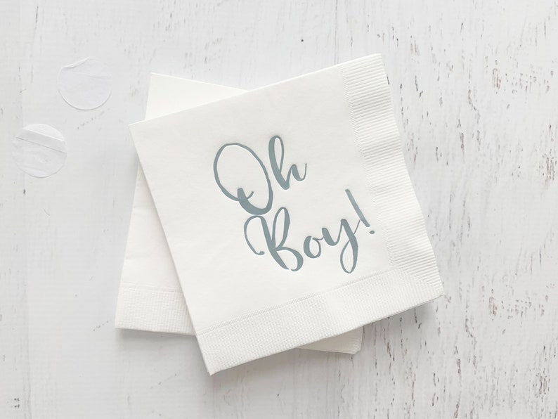 May include: White paper napkins with the text "Oh Boy!" printed in light blue.