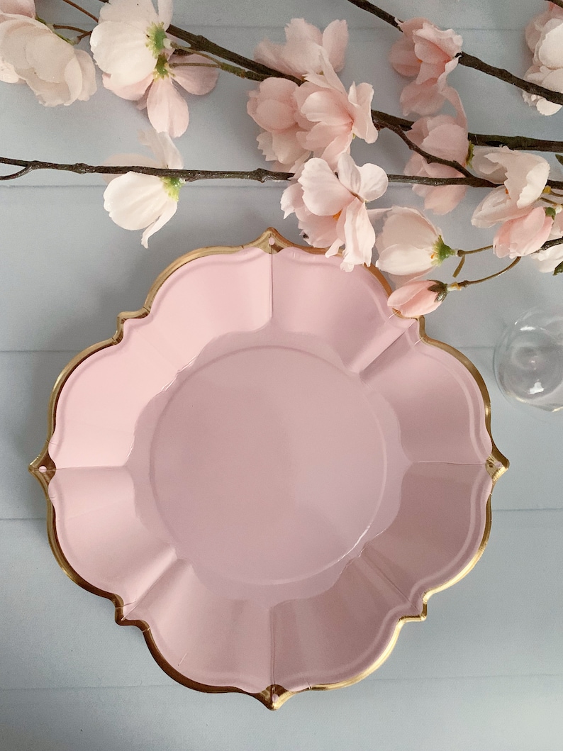 Puede incluir: Un plato de papel rosa con un borde dorado. El plato tiene un borde festoneado y es perfecto para una ocasi&oacute;n especial.