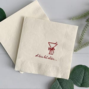 Celebrate a milestone in style with these charming A Tini Bit Older Martini Cocktail Napkins, the perfect addition to any martini-themed birthday party or sophisticated gathering. Designed for lovers of elegant cocktails, these foil-stamped napkins feature a chic illustration of a classic coup martini glass wrapped with a delicate bow around the stem, adding a playful yet refined touch to your celebration. These are perfect for any age birthday, give them as gift for the martini lover.