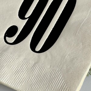 May include: A white paper napkin with the number "90" printed in black.