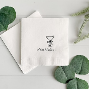 Celebrate a milestone in style with these charming A Tini Bit Older Martini Cocktail Napkins, the perfect addition to any martini-themed birthday party or sophisticated gathering. Designed for lovers of elegant cocktails, these foil-stamped napkins feature a chic illustration of a classic coup martini glass wrapped with a delicate bow around the stem, adding a playful yet refined touch to your celebration. These are perfect for any age birthday, give them as gift for the martini lover.