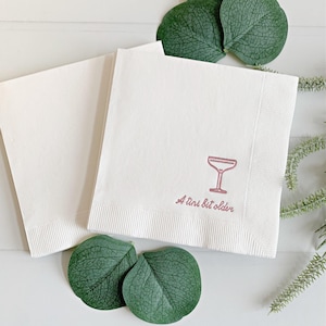 Celebrate a milestone in style with these charming A Tini Bit Older Martini Cocktail Napkins, the perfect addition to any martini-themed birthday party or sophisticated gathering. Designed for lovers of elegant cocktails, these foil-stamped napkins feature a chic illustration of a classic coup martini glass wrapped with a delicate bow around the stem, adding a playful yet refined touch to your celebration. These are perfect for any age birthday, give them as gift for the martini lover.
